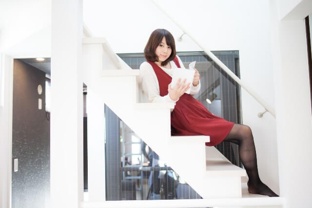 階段で本を読む女性の画像