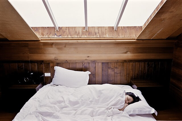 ベッドで寝ている女性の画像